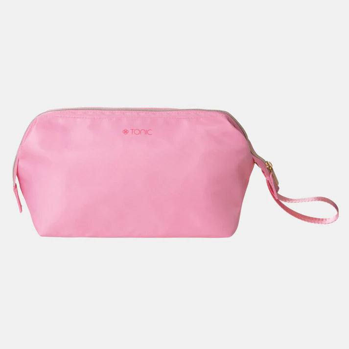 Pink toiletry bag with a strap on a light gray background