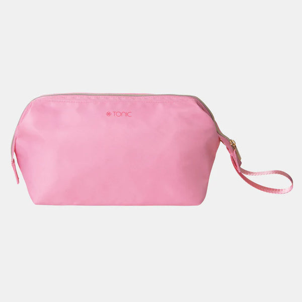 Pink toiletry bag with a strap on a light gray background